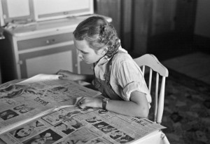 Russell Lee - Rustan's daughter reading a Sunday paper, Rustan brothers' farm near Dickens, Iowa, 1936